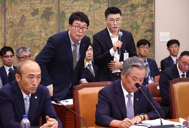 22일 국회에서 열린 문화체육관광위원회 국정감사에서 김택규 대한배드민턴협회장(왼쪽)과 민경국 스포츠에이전시 대표가 안세영 선수와 관련 의원 질의에 답하고 있다. 사진 | 연합뉴스