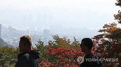 전국이 대체로 흐린 날씨를 보인 28일 단풍이 든 서울 남산 너머로 도심이 옅은 안개와 미세먼지에 갇혀 있다. 기상청은 29일도 전국이 흐리고 제주도, 강원도 일부 지역, 전남해안 지역엔 비가 오는 곳이 있겠다고 예보했다. [연합뉴스]