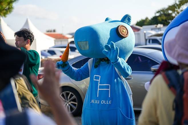 제주올레 마스코트 ‘간세’ 복장을 착용한 자원봉사자 변경아 씨가 올레축제에서 참가자들의 힘을 북돋기 위해  응원하는 모습. (제주올레 제공)