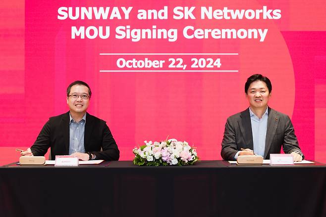 SK Networks President and Chief Operating Officer Choi Sung-hwan (right) and Sunway Group CEO of digital and strategic investments Evan Cheah pose for a photo after signing a memorandum of understanding in Seoul on Oct. 22. (SK Networks)