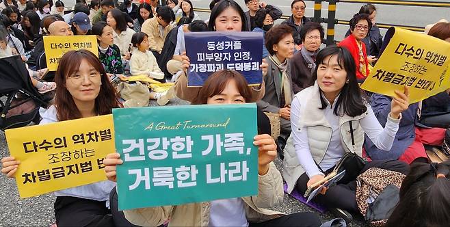 Churchgoers hold signs at the rally against LGBTQ+ at Seoul Plaza on Sunday. (Choi Si-young/The Korea Herald)