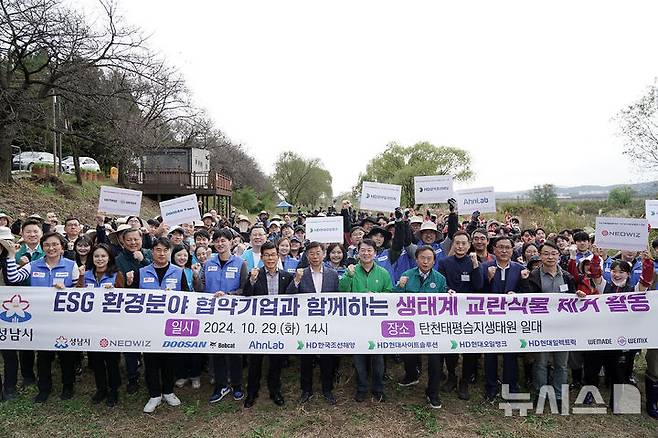 [성남=뉴시스] 성남시가 ESG 환경 분야 협업 기업 8곳 임직원 등과 탄천 일대 생태계 교란 식물 제거 활동을 벌였다 (사진=성남시 제공)