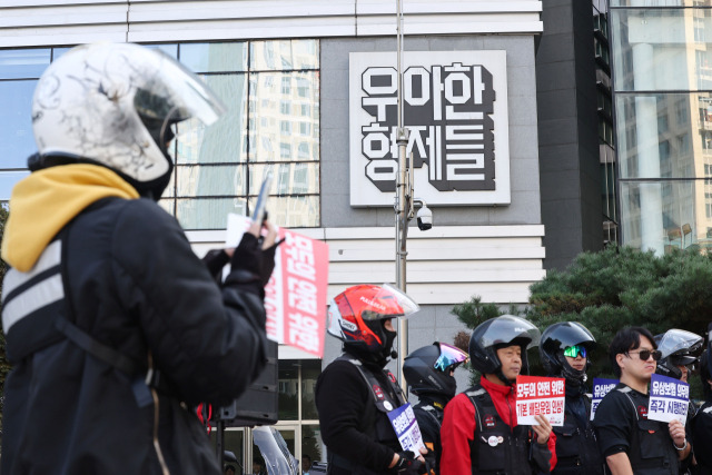 배달플랫폼-입접업체 상생협의체 제9차 회의가 열리는 30일 오후 서울 송파구 우아한형제들 본사 앞에서 라이더유니온 주최로 열린 기본 배달운임 인상 촉구 기자회견에서 한 배달 기사가 현장을 촬영하고 있다. 연합뉴스.