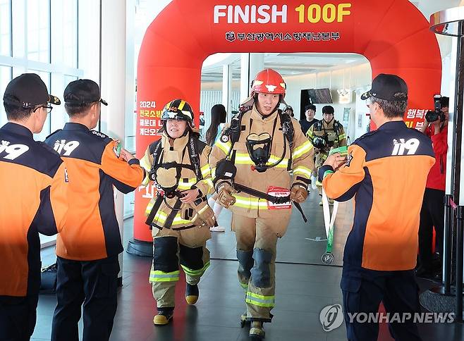 전국소방관 엘시티 계단 오르기 대회 (부산=연합뉴스) 강선배 기자 = 30일 부산 해운대구 엘시티에서 열린 전국소방공무원 엘시티(LCT) 계단 오르기 대회에서 20㎏ 달하는 화재진압 장비를 착용한 소방대원들이 1층에서 100층까지 올라 피니시라인을 통과하고 있다. 2024.10.30 sbkang@yna.co.kr