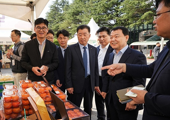 윤석대 한국수자원공사 사장이 30일 임직원들과 함께 댐 주변지역 농가에서 운영하는 농산물 판매장인 이음장날 부스에서 농산물을 살펴보고 있다.[사진=수자원공사]