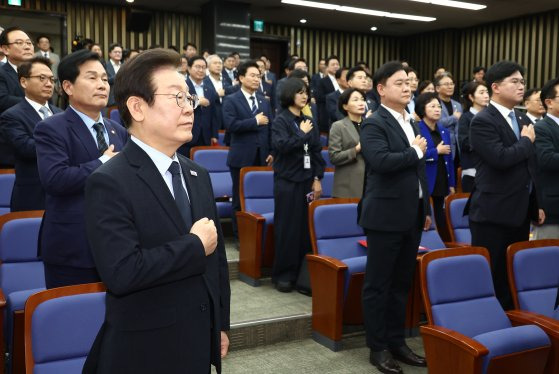 이재명 대표를 비롯한 의원들이 의원총회에서 국민의례를 하고 있다. 뉴스1