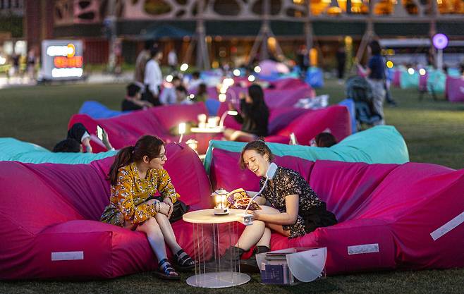 Foreign tourists read books while relaxing in colorful beanbags during the Seoul Outdoor Library event in front of City Hall in central Seoul on Sept. 22. [SEOUL METROPOLITAN GOVERNMENT]
