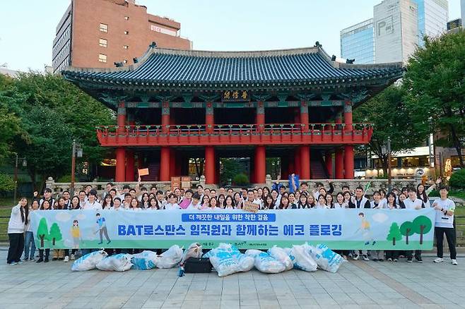 BAT로스만스는 지난 10월31일 명동 관광특구에서 전직원이 참여하는 환경정화 활동 ‘에코 플로깅’ 캠페인을 진행했다. 이날 행사에 참여한 임직원들이 단체사진을 촬영하고 있다.ⓒBAT로스만스