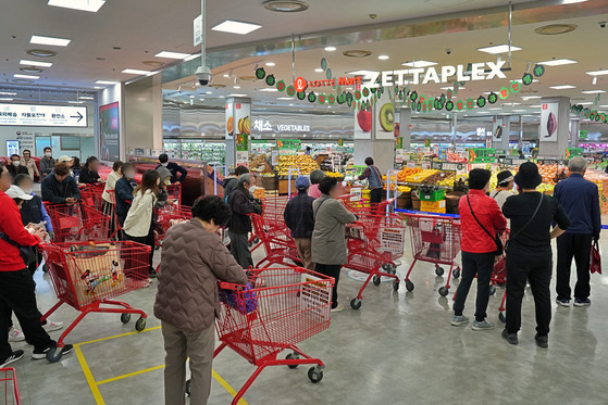 People shop at Lotte Mart on Thursday as its sale event ″Thank You Week″ kicked off. [LOTTE SHOPPING]