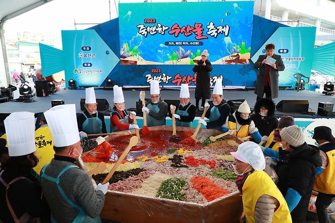 “비빔회 드시러 죽변 오세요” 울진 죽변 수산물 축제장의 초대형 비빔회 퍼포먼스. 여행자에게 나눠준다.