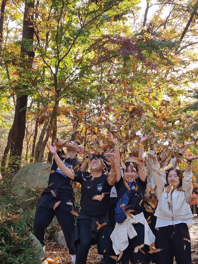 '더피크챌린지' 참가자들이 지난 2일 단풍으로 물든 관악산에서 낙엽을 뿌리고 있다. /한국소비자포럼 제공