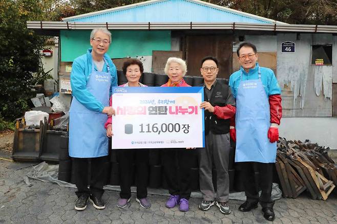 임종룡(왼쪽 첫번째) 우리금융그룹 회장, 장광익 우리금융그룹 부사장(왼쪽 네번째)이 지난 1일 우리금융미래재단 관계자들과 서울 성북구 취약계층 가정집에 연탄 배달을 한 후 마을 주민들과 기념 촬영을 하고 있다. 사진=우리금융그룹 제공