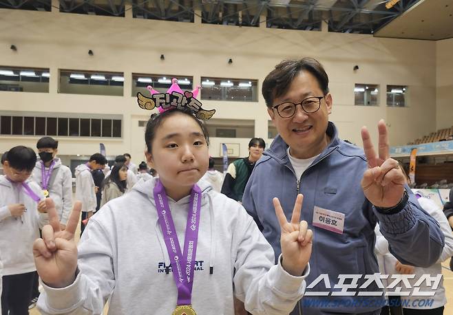 이용호 서울대 체육교육학과 교수(학과장)이 서울림운동회에서 진관중 학생들에게 인증 메달을 걸어준 후 환하게 웃으며 기념사진을 찍고 있다.