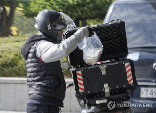 지난달 31일 오후 서울 서초구에서 배달 노동자가 음식 배달을 하고 있다. 연합뉴스