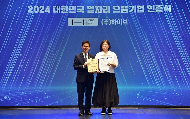 Minister of Employment and Labor Kim Moon-soo (left) poses with Hybe CHRO Kim Ju-young during a "2024 Korea Top Job Creation Company" ceremony held in Seoul, on Sept. 5. Hybe was selected as one of the 100 companies recognized by the government. (Hybe)
