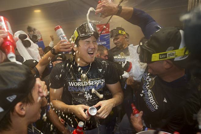 LA다저스의 오타니 쇼헤이가 31일 열린 MLB 월드시리즈에서 우승을 확정한 뒤, 동료들과 함께 샴페인을 터트리면서 기쁨을 나누고 있다. AP연합뉴스