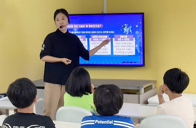 LG이노텍이 운영하는 ‘소재·부품 과학교실’에 참여한 어린이들이 디지털 트윈 기술 설명을 듣고 있다. <LG이노텍>