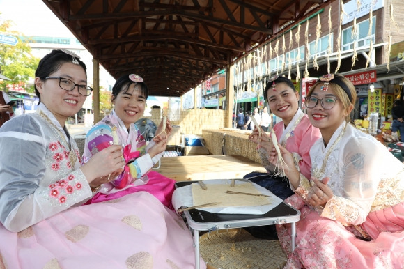 지난달 3일부터 13일까지 열린 제42회 금산세계인삼축제에 참가한 외국인들이 인삼 껍질을 벗기면서 즐거워하고 있다.  금산군 제공