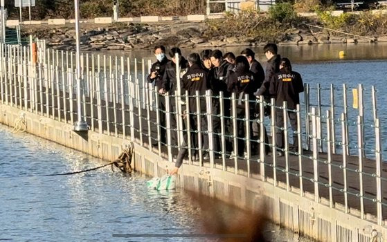 6일 강원 화천군 북한강에서 함께 근무하던 여성 군무원을 살해한 뒤 시신을 훼손하고 북한강에 유기한 현역 군 장교 A(38)씨에 대한 현장 검증이 진행되고 있다. 사진은 A씨가 다리 위에서 훼손된 시신이 담긴 봉투를 강 아래로 떨어뜨리는 범행 당시 상황을 재연하는 모습. 연합뉴스