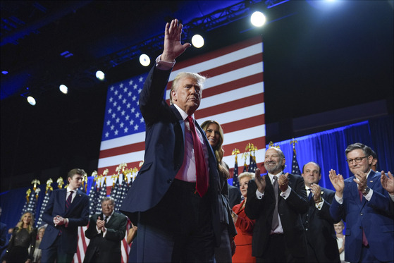 Republican presidential candidate and former President Donald Trump, center, waves as he walks with former first lady Melania Trump at an election night watch party at the Palm Beach Convention Center on Wednesday in West Palm Beach, Florida. [AP/YONHAP]