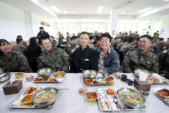 백종원 더본코리아 대표가 7일 경기도의 한 군 부대에서 열린 더본코리아 특식제공 행사에서 부대 취사병과 기념사진을 찍고 있다. 뉴스1