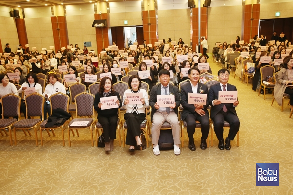 2024년도 제11회 전국국공립&nbsp;보육인대회 참석자들이&nbsp;"국공립어린이집을 국공립으로!" 슬로건이 적힌 자료집을 들고 기념촬영을 하고 있다. ⓒ전국국공립어린이집연합회