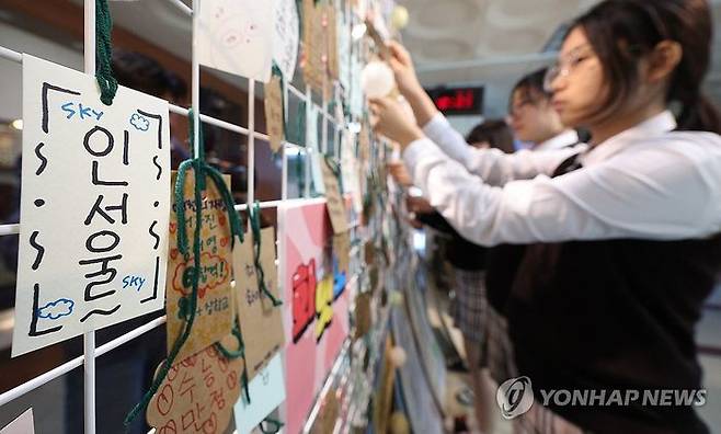 2025학년도 대학수학능력시험을 일주일 앞둔 7일 오전 대구 북구 매천고등학교 교정에서 2학년 학생들이 수능 응원 부적을 게시판에 달고 있다.ⓒ연합뉴스
