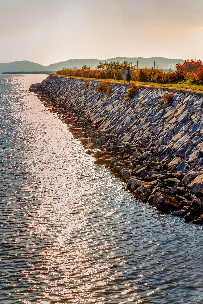 '보문 선착장'과 나란히 있는 복합휴게소를 지나면 제방길이 이어진다. 해가 느슨해지는 오후에 홀로 이 길을 걸으면 없던 시심(詩心)이 꿈틀댈 만큼 서정적인 풍경과 마주할 수 있다. / 이건송 영상미디어 기자