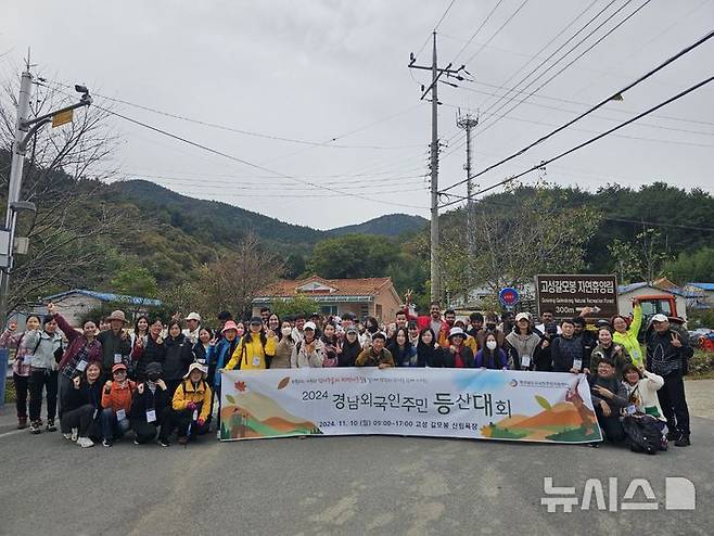 [창원=뉴시스]10일 경남 고성군 고성갈모봉 자연휴양림 입구에서 경남외국인주민지원센터 주관 '경남 외국인주민 등산대회'에 참여한 외국인주민들이 기념촬영하고 있다.(사진=경상남도외국인주민지원센터 제공02024.11.10. photo@newsis.com