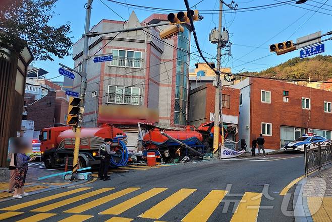 12일 오전 부산 동구 범일동 한 경사로에 주차된 5톤 정화조 차량이 80m 가량 뒤로 미끄러져 상가건물 등이 파손돼 있다. (부산경찰청 제공)