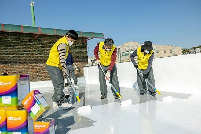 KCC와 서울시건축사회 관계자들이 KCC의 스포탄상도(에너지) 페인트를 활용해 시원한 옥상 만들기 작업을 하고 있다. KCC 제공