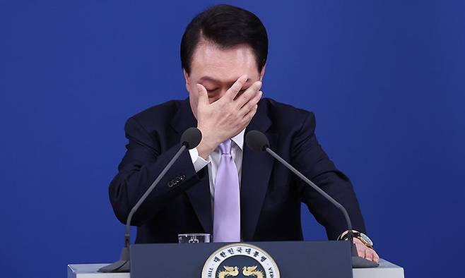 윤석열 대통령이 지난 7일 서울 용산 대통령실 청사 브리핑실에서 열린 대국민담화 및 기자회견 중 얼굴을 매만지고 있다. 뉴스1