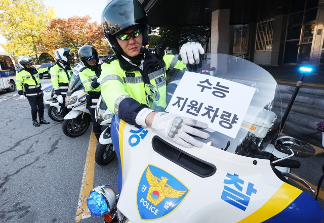 대학수학능력시험을 사흘 앞둔 11일 오전 경기도 수원시 영통구 수원남부경찰서에서 경찰관들이 수능 특별 교통관리에 사용될 경찰 오토바이와 순찰차에 안내문을 부착하고 있다. 연합뉴스