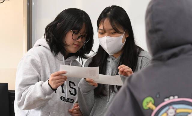 2025학년도 대학수학능력시험 예비소집일인 13일 인천 미추홀구 인화여자고등학교에서 수험생들 수험표를 받고 확인하고 있다. 조병석기자