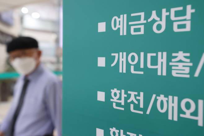 서울 한 시중은행의 대출 안내문 앞을 시민이 지나가고 있다.[연합]