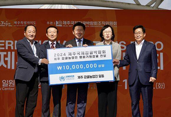 제주 감귤 농업인들이  ‘평화후원금’을 유엔난민기구(UNHCR)에 전달하고 있다. [사진=제주특별자치도 ]