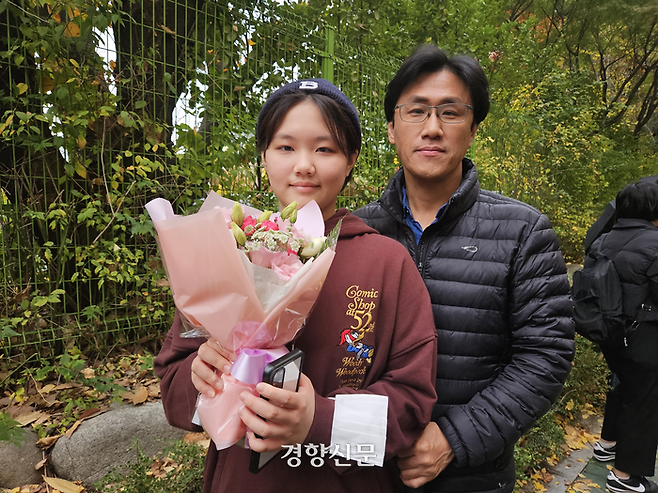 김연우양(15)이 14일 서울 영등포구 여의도여고 앞에서 아버지와 꽃다발을 들고 수험생 언니가 나오길 기다리고 있다. 김송이 기자