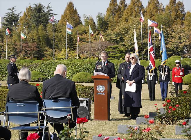 Maj. Patrick Arthur Angier's grandson Guy Puzey, center, gives a reading at the ceremony to mark the rededication of the graves of his grandfather and three other previously unknown British soldiers at the United Nations Memorial Cemetery in Busan on Tuesday. Maj. Angier's daughter Tabby Angier stands next to him on the right. Reverend Alan Cobain, who conducted the ceremony, stands behind the pair. [PARK SANG-MOON]