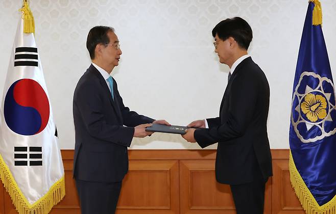 한덕수 국무총리(왼쪽)가 14일 서울 종로구 정부서울청사에서 열린 지속가능발전국가위원회 위촉장 수여식에서 정철영 국가위원장에게 위촉장을 전하고 있다. [연합뉴스]