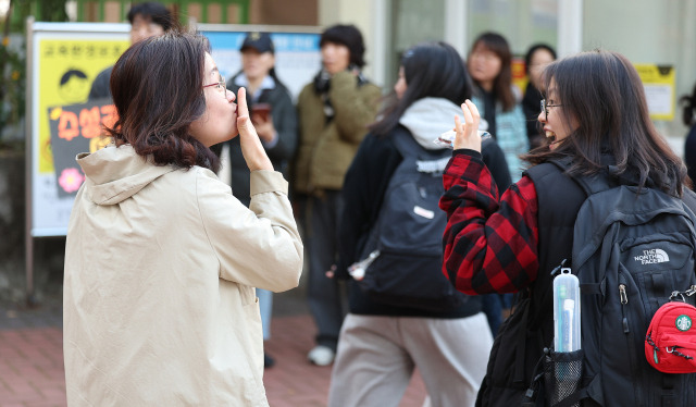 2025학년도 대학수학능력시험일인 14일 오전 대구 수성구 대구여자고등학교 수능 시험장 앞에서 한 학부모가 수험생을 응원하고 있다. 연합뉴스