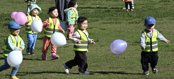 가을소풍… 신나는 풍선놀이 - 포근한 가을 날씨가 이어진 14일 오전 제주시 도남동 시민복지타운광장에서 소풍 나온 유아들이 풍선을 들고 뛰어놀고 있다. 15일 아침 최저기온은 9∼16도, 낮 최고기온은 19∼21도로 예보됐다. 제주 연합뉴스