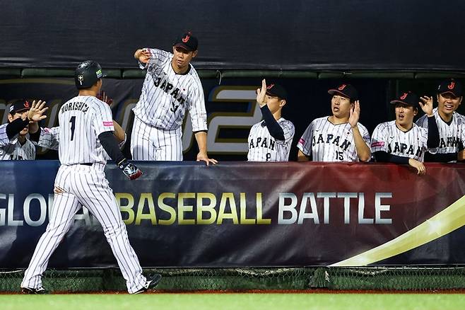 일본 모리시타 쇼타가 17일 대만 타이베이 톈무구장에서 열린 2024 세계야구소프트볼연맹(WBSC) 쿠바전에서 득점에 성공한 후 동료들과 하이파이브랄 하고 있다. 사진 | 타이베이=AFP연합뉴스