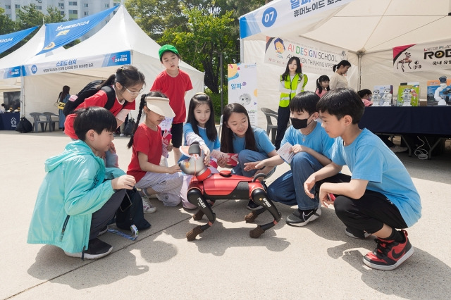 서울 양천구가 지난 5월 주최한 ‘Y교육박람회’에서 아이들이 로봇 강아지를 만져보며 대화하고 있다. 양천구 제공