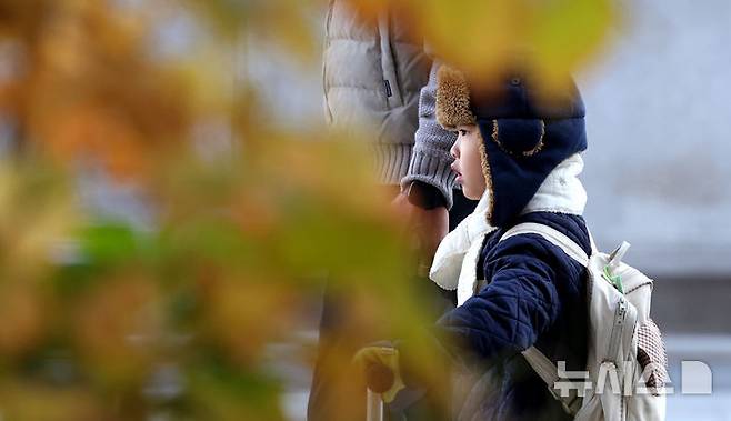 [서울=뉴시스] 추상철 기자 = 입동을 앞두고 기온이 뚝 떨어진 지난 6일 오전 서울 종로구 세종대로사거리에서 털모자와 목도리를 한 아이가 아빠와 함께 길을 지나고 있다. 2024.11.06. scchoo@newsis.com