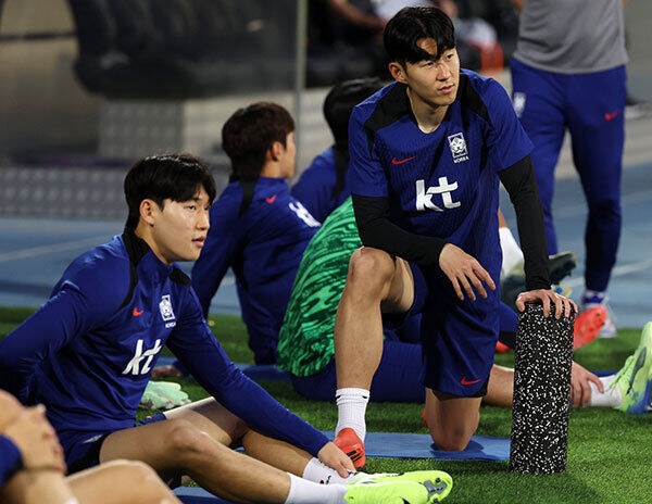 축구 대표팀 손흥민이 쿠웨이트 압둘라 알 칼리파 스타디움에서 몸을 풀며 배준호와 대화를 하고 있다. 뉴시스