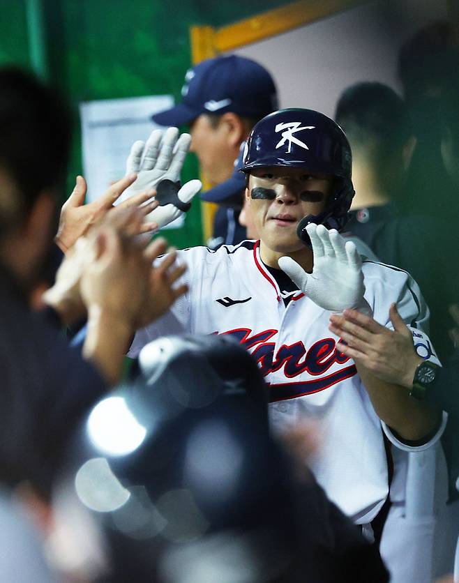 한국 야구대표팀 김도영이 14일 대만 타이베이 톈무구장에서 열린 쿠바와의 세계야구소프트볼연맹(WBSC) 프리미어12 조별리그 B조 2차전에서 7회 솔로홈런을 친 뒤 더그아웃에서 동료들과 하이파이브하고 있다. 타이베이 | 연합뉴스