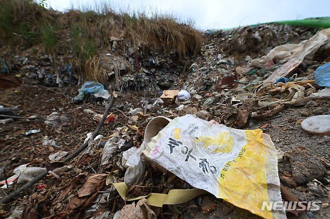 [광주=뉴시스] 이영주 기자 = 광주 서구 풍암동 중앙공원 제1지구 공사현장 주변 야산에서 30여년 전 매립된 쓰레기들이 지난달 배수로 공사 도중 무더기로 발견됐다. 발견된 6000여t 쓰레기는 시공사에서 처리할 방침이나 공사 과정에서 추가로 나오는 쓰레기 처리 여부 등은 협의를 거쳐야 한다. 2024.06.20.leeyj2578@newsis.com