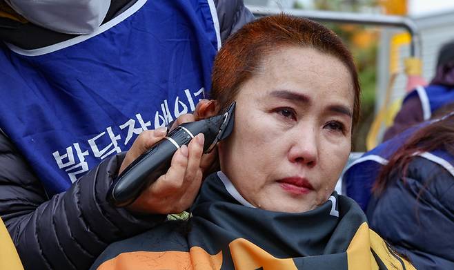 19일 서울 여의도 국회 앞에서 2025 발달장애 예산확대 투쟁 전국장애인부모연대 삭발투쟁선포 및 전국결의대회에서 한 학부모가 삭발을 하며 눈물을 흘리고 있다.