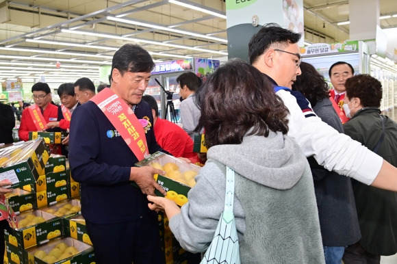 윤경희(왼쪽) 경북 청송군수가 지난 15일 서울 양재 하나로마트에서 꼭지사과를 홍보하고 있다.  청송군 제공