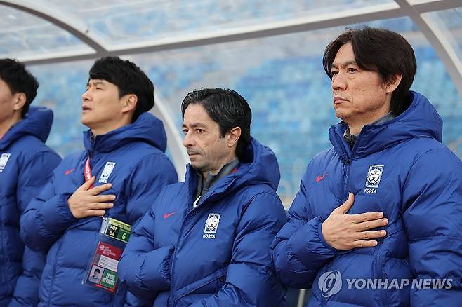 국기에 경례하는 홍명보 감독과 코치진 (암만[요르단]=연합뉴스) 황광모 기자 = 19일 오후(현지시간) 요르단 암만 국제경기장에서 열린 2026 북중미 월드컵 아시아 3차 예선 B조 한국과 팔레스타인의 경기.
    한국 축구대표팀 홍명보 감독 및 코치진이 국기에 경례하고 있다. 2024.11.19 hkmpooh@yna.co.kr